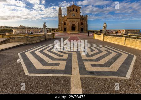 The Bażilika Tal-Madonna Ta' Pinu (Basilica of Our Lady of Ta' Pinu) near Għarb on Gozo, Malta. In front of the neo-Romanesque church, built between 1920 and 1931 to designs by architect Andrea Vassallo on the site of a small chapel, a large labyrinth pattern is set into the paving of the square; side walls with mosaics depict the mysteries of the rosary. Stock Photo