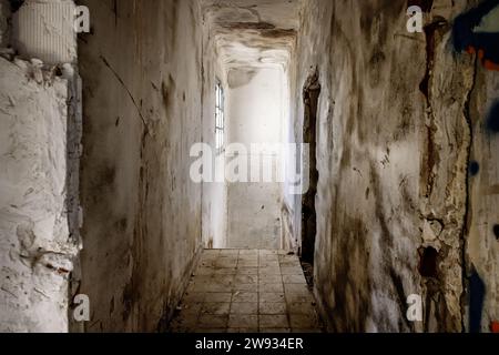 A dark hallway of an abandoned building with dirt Stock Photo