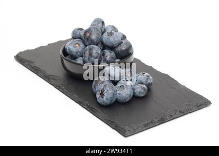 Blueberries on black slate and isolated on white background. Stock Photo