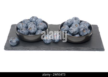 Blueberries on black slate and isolated on white background. Stock Photo