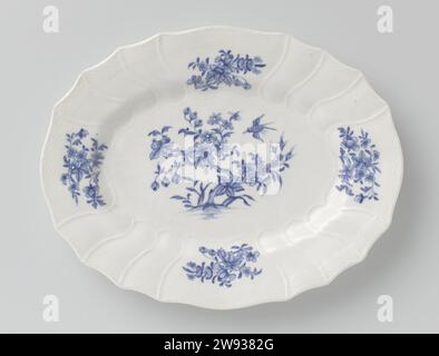Dish with flowering plants and flower sprays, Doornik, 1790 - 1800 dish Oval scale of soft-pale porcelain (pâte tendre) with a scalloped edge, painted in underlaze blue. On the flat a bird and a butterfly with a flowering plant. The edge, continuously on the wall, is slightly modeled in three narrow and one wide -ranged box. A flower branch in the four wide courses. Above a bond with braid work in relief. Marked on the underside with the crossed swords with four crosses and an N. Torlative porcelain. glaze. cobalt (mineral) painting / vitrification Stock Photo