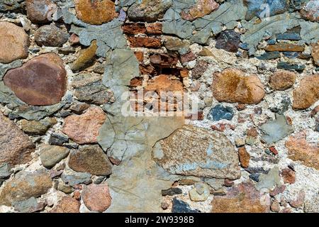 ancient wall of cobblestones and red bricks, combined ancient wall of red clay bricks and stones Stock Photo