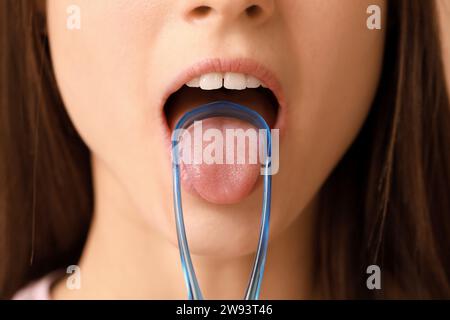 Young woman with tongue scraper, closeup Stock Photo
