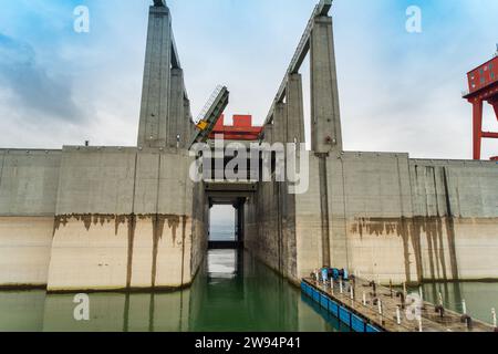 Panoramic view of the Three Gorges Dam, the largest hydroelectric power plant in the world. The sky is blue and clear and the sun is shining brightly. Stock Photo