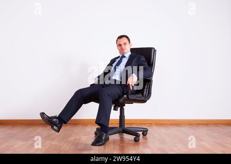 Businessman having fun with his chair Stock Photo