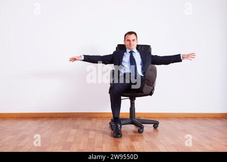 Businessman having fun with his chair Stock Photo