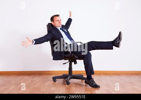 Businessman having fun with his chair Stock Photo