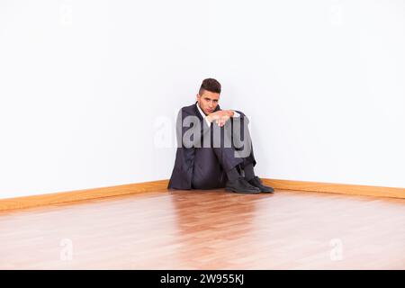 Businessman at the corner of his office room with fear Stock Photo