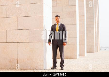 Sad businessman next to some wall looking down Stock Photo