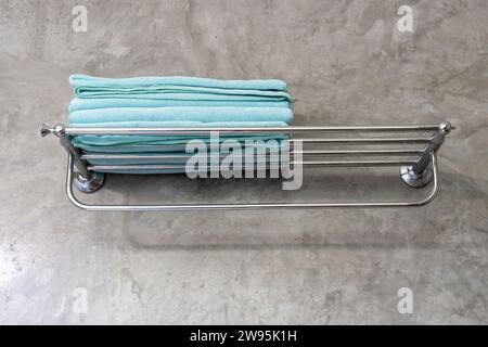 Blue towel is folded tidily on shelf in resort restroom or toilet prepared for guests. Stock Photo