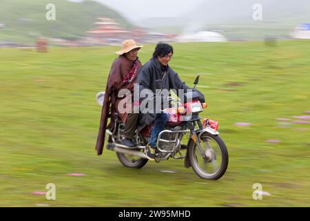 Tibetan men on motorbike at horse festival nr Daofu; Tibetan area; Sichuan; China Stock Photo