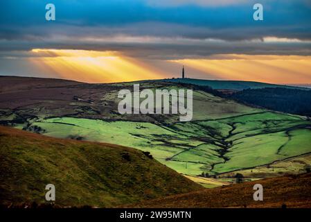 Setting sun over the Peak district hills looking across Wildboarclough towards the Congleton television transmitter. Stock Photo