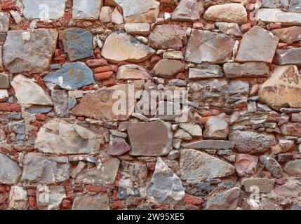 Background of ancient bricks and stones in a wall some of which are blue Stock Photo