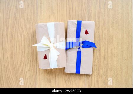 Christmas gift parcels wrapped in brown paper and tied up with a blue and cream ribbon Stock Photo