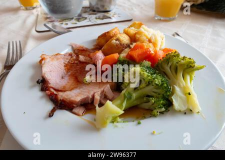 A dinner of home cooked roast gammon with potatoes, broccoli and carrots Stock Photo