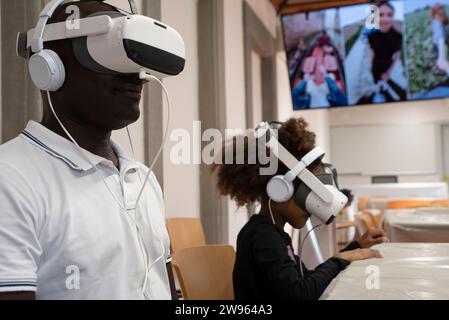Father and daughter are having fun using VR virtual reality equipment. African ethnicity. Stock Photo