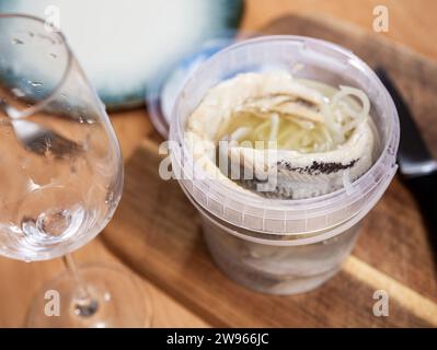In plastic bucket containers are large pieces of salted herring fillet, freed from bones Stock Photo