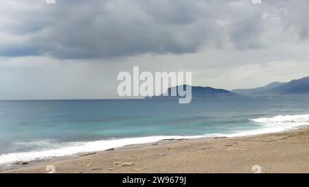 Sea coast, stormy sky over turquoise sea, view from shore. Stock Photo