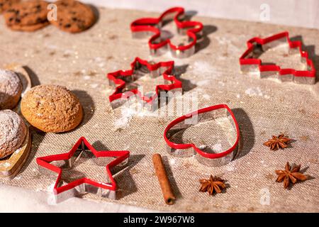Background with cookie cutters, cookies, anise and cinnamon sticks. Selective focus. Stock Photo
