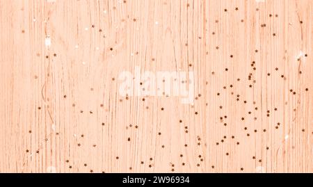 Stars on a wooden peach background. color of the year 2024 Stock Photo