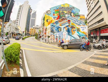 Kuala Lumpur- Malaysia- January 21-2023- Cars in downtown traffic with colorful paintings on buildings Stock Photo