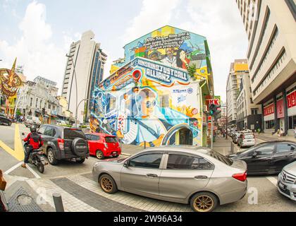 Kuala Lumpur- Malaysia- January 21-2023- Cars in downtown traffic with colorful paintings on buildings Stock Photo