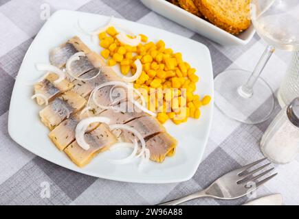 Sliced pickled herring fillet with corn and onions Stock Photo