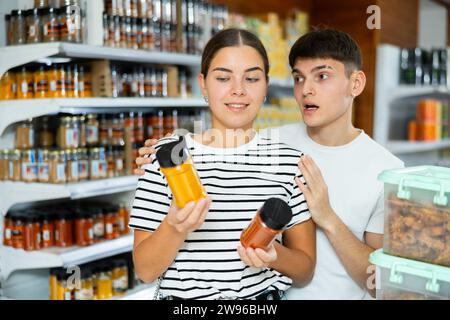 Young couple chooses and buys delicious spices together in a supermarket Stock Photo