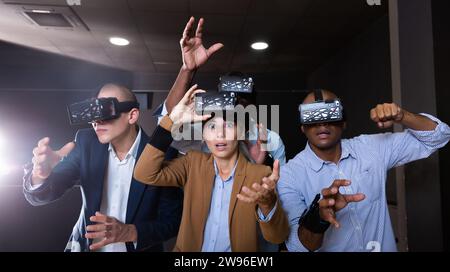 Cheerful nice friends playing video games using virtual reality glasses Stock Photo