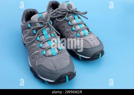 Hiking Male Trekking Footwear, Waterproof Non Slip Mountain Shoes, Adventurer Boots on Blue Background, Heavy-duty Tread Outsole. Man's Durable Stock Photo