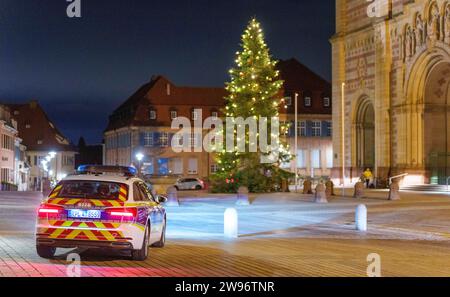 Speyer, Germany. 25th Dec, 2023. A police car is parked in front of Speyer Cathedral. Christmas mass in Speyer Cathedral is celebrated by an auxiliary bishop to the sounds of the cathedral choir and the cathedral organist. Credit: Andreas Arnold/dpa/Alamy Live News Stock Photo