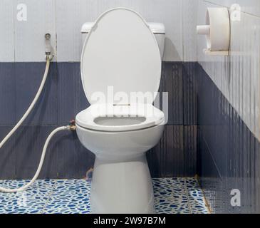 White toilet bowl with bidet sprayer in resort or hotel toilet was taken after use. Stock Photo