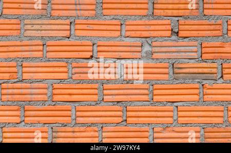 Orange or red brick wall used as background texture is set in beautiful horizontal pattern in residence or home building, red stone block close up. Stock Photo
