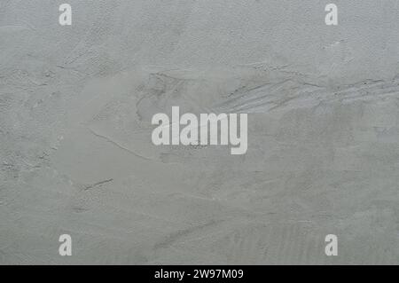 Unfinished facing wall with strange scratches in home or residence building, gray cemented wall is used as background texture. Stock Photo