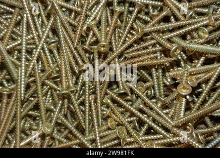 Close-up of a variety of metal screws arranged neatly on a workbench in a shop setting Stock Photo