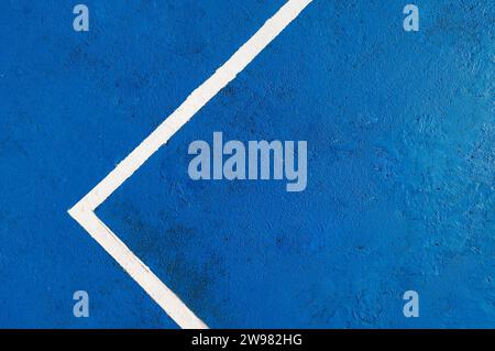 Blue textured court surface featuring a white boundary line forming an angle Stock Photo