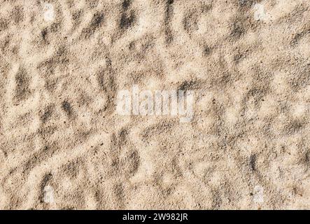 Dry sand creating an abstract textured background with shadows and light Stock Photo