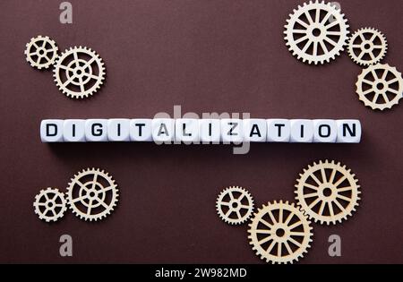 Wooden gears with word Digitalization. Stock Photo