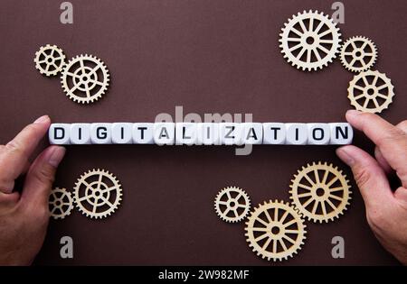 Wooden gears with word Digitalization. Stock Photo
