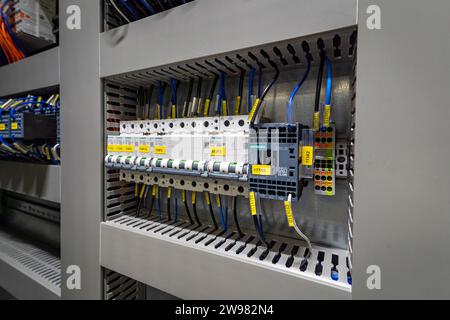 A close-up shot of a variety of electrical cables, cords, and wires inside an electronic cabinet Stock Photo