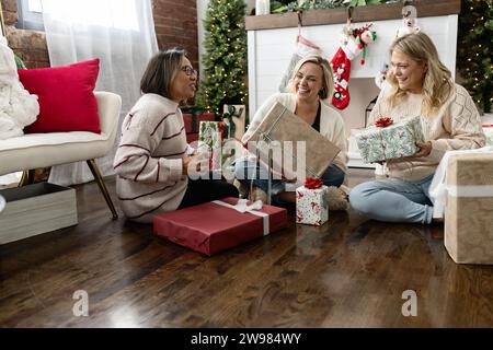 Friends exchanging christmas presents smiling and laughing Stock Photo