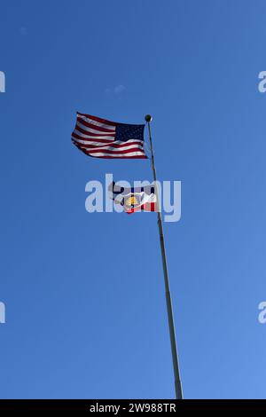 The American flag and the Utah State flag flown together on a long pole at the campus of Utah State University Stock Photo