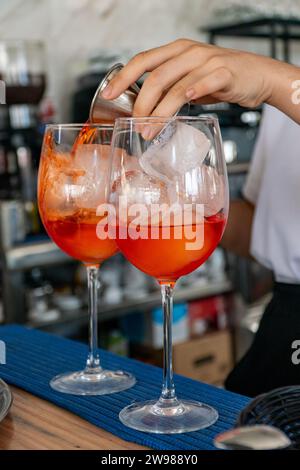 a bartender preparing a pair of Italian Aperol spritz cocktails at a mediterranean bar Stock Photo