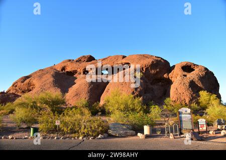 People sitting on the red sandstone of Hole in the Rock while enjoying the sunset Stock Photo