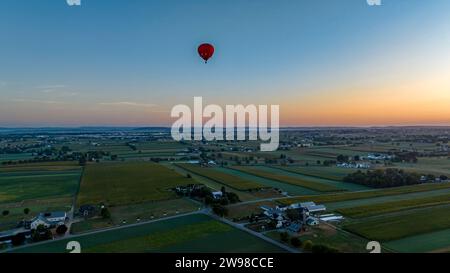 An Aerial View of a Red Hot Air Balloon, Floating Across Rural Pennsylvania, on a Sunny Morning, in the Summer Stock Photo