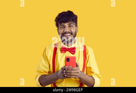 Smiling Indian man use modern cellphone texting Stock Photo