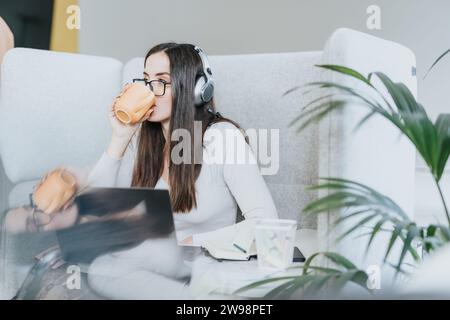 Successful businesswoman analyzing statistics and discussing financial planning while enjoying her first morning coffee at work. Stock Photo