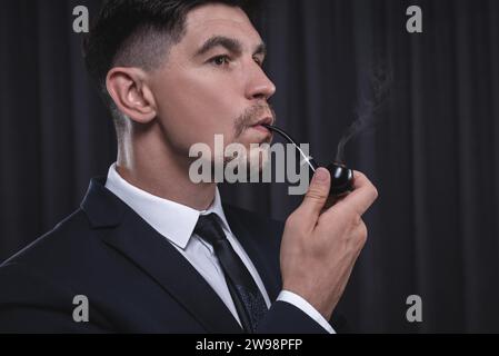 Image of an elegant man in a suit smoking a pipe. Business success concept. Mixed media Stock Photo