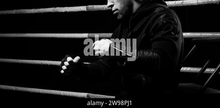 Mixed martial artist wraps bandages around his fist. Concept of mma, ufc, thai boxing, classic boxing. Mixed media Stock Photo