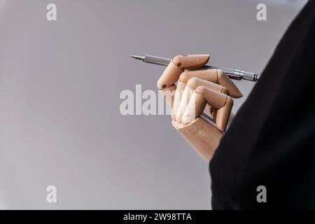 Hold a metallic pencil wooden puppet hand Stock Photo